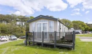 a tiny house on the grass in a parking lot at Nv48 Luxury static caravan at beautiful durdle door holiday park in West Lulworth