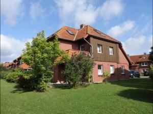 a large brick house with a tree in the yard at Wohnung mit Balkon und Aussicht in Petersdorf auf Fehmarn