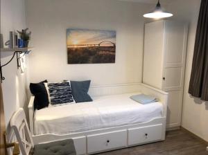 une petite chambre avec un lit blanc et un tableau dans l'établissement Kieferneck, à Petersdorf auf Fehmarn