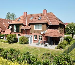 une grande maison avec un toit rouge dans l'établissement Kieferneck, à Petersdorf auf Fehmarn
