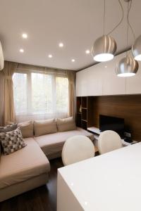 a living room with a couch and some chairs at Lozenets Apartment in Sofia