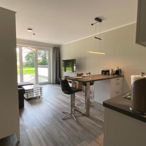 eine Küche und ein Wohnzimmer mit Tisch und Stühlen in der Unterkunft Columbus in Petersdorf auf Fehmarn