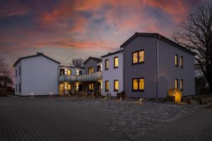 a large white house with a cloudy sky at night at Columbus in Petersdorf auf Fehmarn