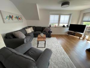 un soggiorno con un divano e una TV di Little Welcome a Petersdorf auf Fehmarn