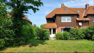 una grande casa con tetto rosso di Bunte Kuh a Petersdorf auf Fehmarn