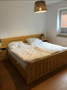 a bed sitting in a bedroom with a window at Lieblingsplatz in Petersdorf auf Fehmarn