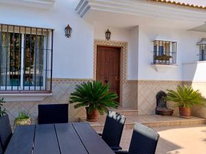 een patio met een houten tafel en stoelen bij La Casa Del Platero in Ronda