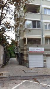 a building with a garage on the side of a street at Lozenets Apartment in Sofia