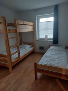 a bedroom with two bunk beds and a window at Auszeit in Wenkendorf auf Fehmarn