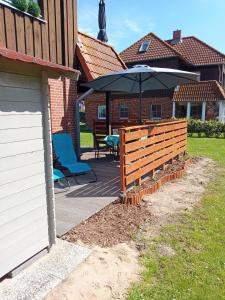 a patio with a table and an umbrella at Auszeit in Wenkendorf auf Fehmarn