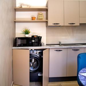 a kitchen with a washing machine and a sink at Fiore dei Templi - luxury suite experience in Agrigento