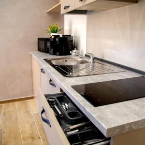 a kitchen counter with a sink and a stove at Fiore dei Templi - luxury suite experience in Agrigento +7 photos