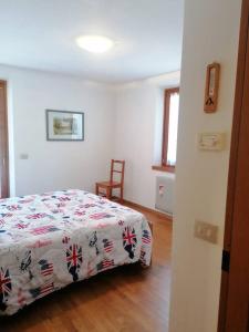 a bedroom with a bed with a flowered blanket at MountainHome Garage and Free Parking in Bocenago