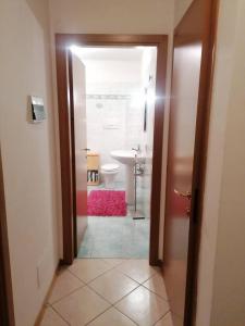 an open door to a bathroom with a sink and a toilet at MountainHome Garage and Free Parking in Bocenago +6 photos