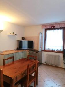 a kitchen with a table and a television and a table and chairs at MountainHome Garage and Free Parking in Bocenago