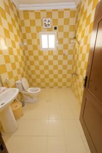 a yellow bathroom with a toilet and a sink at غرفه وصاله بدخول ذاتي in Jeddah