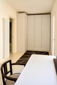 ヴィアレッジョにあるFront Beach Apartments - Deluxeの白いキャビネットとテーブルと椅子のあるキッチン