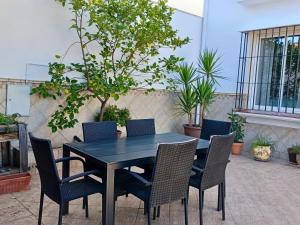 een zwarte tafel en stoelen op een patio met planten bij La Casa Del Platero in Ronda