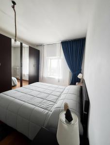 a bedroom with a large bed with a blue curtain at SWEET APT Piazza Statuto 9 Deluxe NEL PIENO CENTRO DI TORINO in Turin