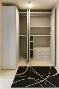 ヴィアレッジョにあるFront Beach Apartments - Deluxeの白いキャビネットと黒いラグが敷かれたクローゼット +10枚の写真