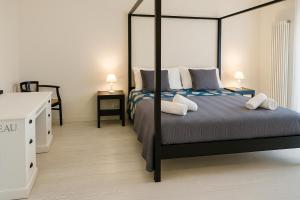 ヴィアレッジョにあるFront Beach Apartments - Deluxeのベッドルーム1室(天蓋付きベッド1台、ナイトスタンド2台付)