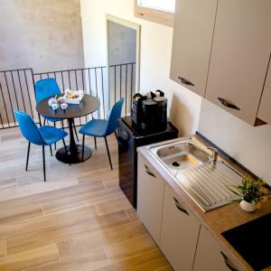 a kitchen with a table and chairs and a table and a sink at Fiore dei Templi - luxury suite experience in Agrigento