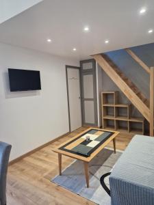 a living room with a table and a tv at Baie du Mont Saint Michel, petite maison neuve in Pontorson +17 photos