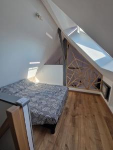 a bedroom with a bed under a stair case at Baie du Mont Saint Michel, petite maison neuve in Pontorson