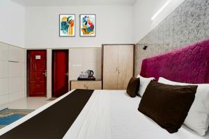 a bedroom with a large bed and a red door at Collection O Perumalmalai Bus Terminal Formerly Raja Garden Hill View in Kodaikānāl