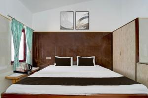 a bedroom with a large bed and two windows at Collection O Perumalmalai Bus Terminal Formerly Raja Garden Hill View in Kodaikānāl