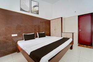 a large bed in a room with a red door at Collection O Perumalmalai Bus Terminal Formerly Raja Garden Hill View in Kodaikānāl