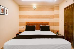 a bedroom with a large bed with a wooden headboard at Townhouse Gomti Nagar Station Formerly Budget In in Gomti Nagar