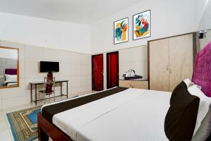 a bedroom with a large bed and a tv at Collection O Perumalmalai Bus Terminal Formerly Raja Garden Hill View in Kodaikānāl