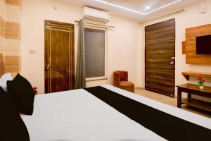 a hotel room with a bed and a television at Townhouse Gomti Nagar Station Formerly Budget In in Gomti Nagar