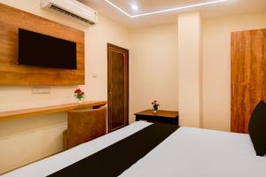a bedroom with a bed and a flat screen tv at Townhouse Gomti Nagar Station Formerly Budget In in Gomti Nagar