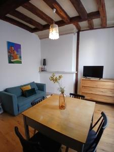 a living room with a table and a blue couch at T2 Centre ville - rdc in Angers