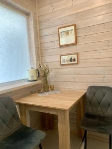 a wooden table with two chairs and a window at Еко апартаменти DOM Art in Ovruch +34 photos