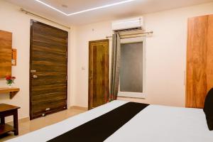 a bedroom with a bed and a large window at Townhouse Gomti Nagar Station Formerly Budget In in Gomti Nagar
