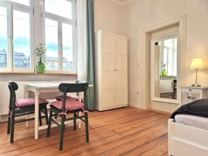 a bedroom with a table and chairs and a bed at Bahnhof Grombach in Bad Rappenau