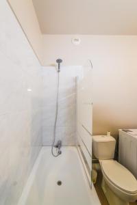 a white bathroom with a toilet and a shower at L Icone de la Guierle - 1 Chambre in Brive-la-Gaillarde