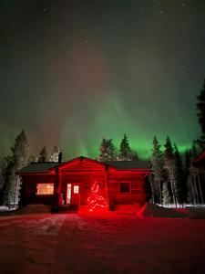 een huis met een kerstboom ervoor bij Villa Kelo in Rovaniemi