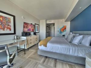 una camera da letto con un letto, una scrivania e una TV di MVR Need Space Style - Book This Suite a Miami