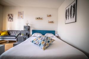 una camera da letto con un letto grande con testiera blu di Le Joyau - 1 Chambre a Brive-la-Gaillarde