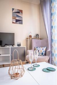 un soggiorno con tavolo e 2 bicchieri di Le Joyau - 1 Chambre a Brive-la-Gaillarde