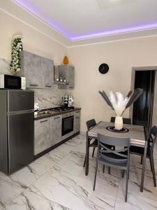 カターニアにあるVicolo30のテーブル付きのキッチンと冷蔵庫付きのキッチン