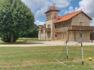 a field with a soccer ball in front of a building at Gîte atypique au style industriel (Classé 4****) in Feugarolles