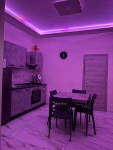 カターニアにあるVicolo30のキッチン(テーブル、椅子、紫色の照明付) +2枚の写真