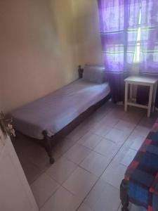 a small bed in a room with a window at Sabel's Retreat in Elephant Island