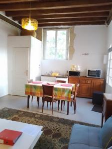 eine Küche mit Tisch und Stühlen in einem Zimmer in der Unterkunft La maison blanche in Nazelles