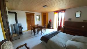 une chambre avec un lit, une table et des chaises dans l'établissement Coeur de Village du Haut-Jura, à Les Bouchoux